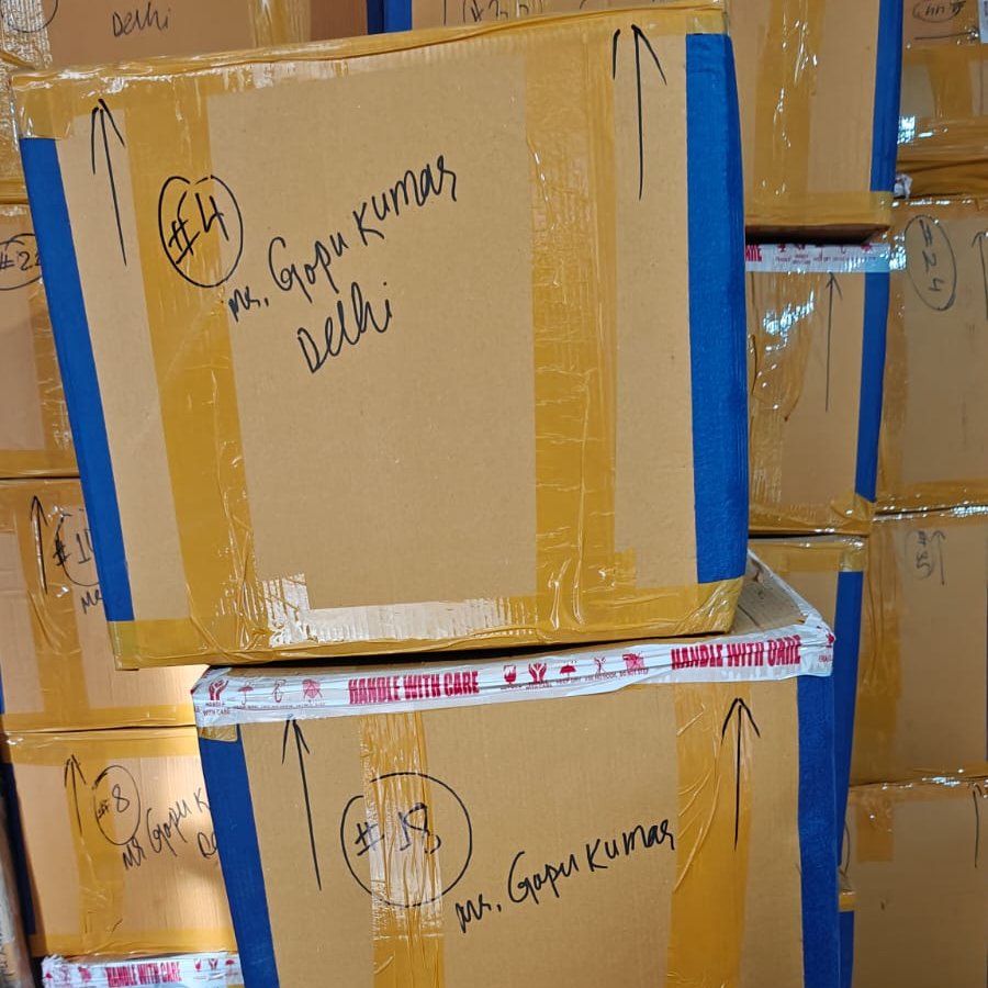 Two movers strapping a wrapped item during an office relocation