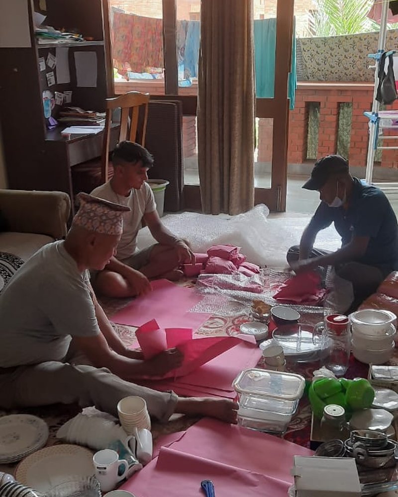 Crew wrapping glassware and crockery for export packing